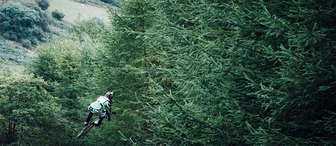 Mountain Biker riding off jump high in the air